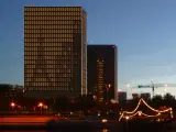 man closes window shades in city